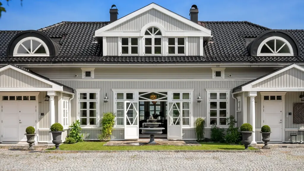 Herskapelig herregård med stort hovedhus, garasje, stall og låve- utsikt utover Lierdalen